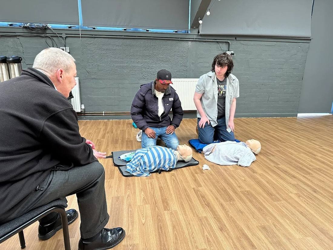 Delegates practising infant CPR on paediatric manikins during an on-site paediatric first aid course