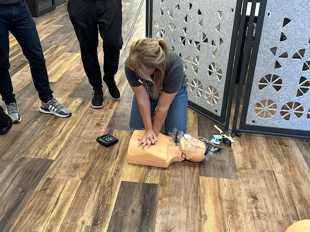 A delegate practising chest compressions on a CPR manikin during an on site first aid course